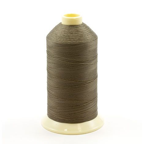 Premium Photo  Spool of brown string in hand on black background
